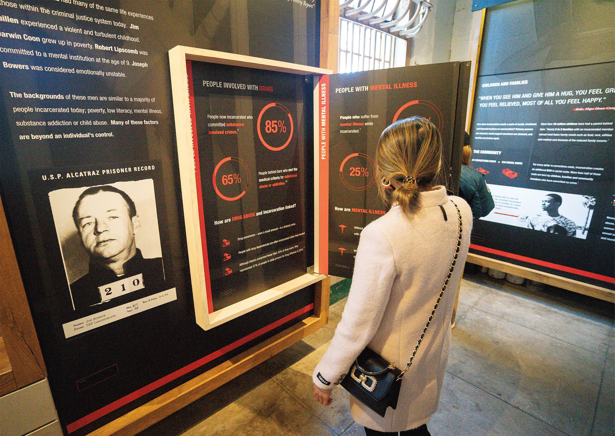 A visitor views charts in The Big Lockup exhibit about Alcatraz and incarceration