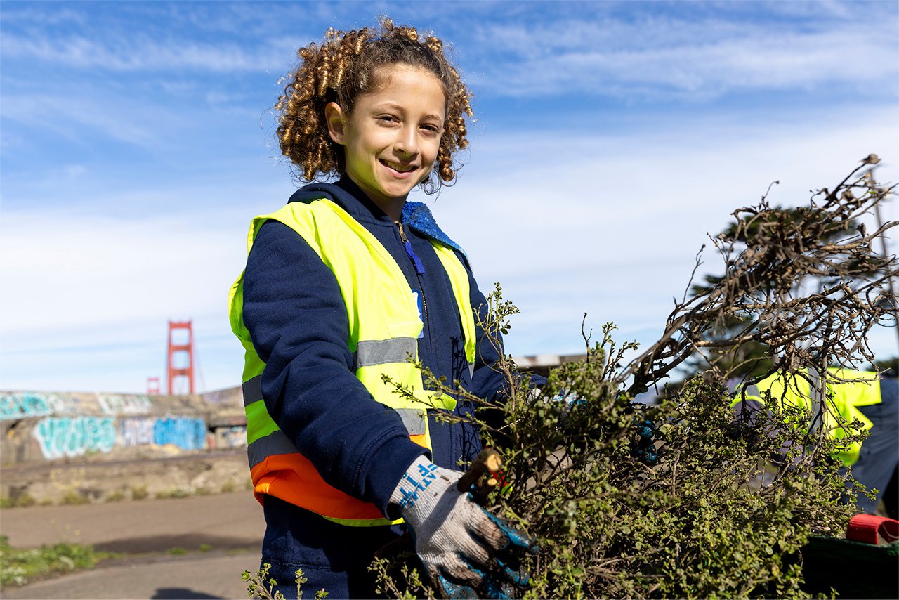 A young volunteer helps clean up the Batteries at Golden Gate Overlook on MLK Day of Service. January 15, 2024. Photo by Lizzy Myers.